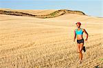 Young woman running across field, Bainbridge Island, Washington State, USA
