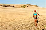 Young woman running across field, Bainbridge Island, Washington State, USA