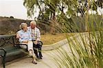 Husband and wife chatting lovingly on park bench