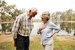 Husband and wife sharing joke by the lake