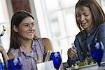 Two women seated at a cafe table having a meal.