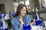 A woman seated in a cafe using a smart phone.