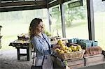 An organic fruit and vegetable farm. A young woman sorting vegetables.