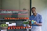 An organic fruit and vegetable farm. A man sorting vegetables.