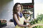 An organic farm stand. A woman sorting vegetables.