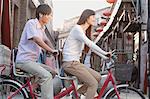 Side View of Young Heterosexual Couple on a Tandem Bicycle in Beijing