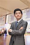 Young businessman with arms crossed at the airport, Beijing, China