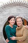 Grandmother and granddaughter in front of round arch, Beijing