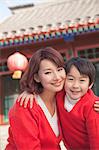 Portrait of mother and son outside traditional Chinese building