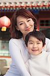 Portrait of mother and son outside traditional Chinese building