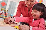 Teacher Helping Young Girl with Cut-Out Alphabet Letters