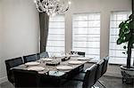 Dining room with modern furniture and chandelier.