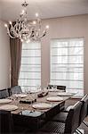 Dining room with modern furniture and chandelier.