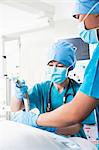 Surgeon looking down and holding surgical equipment in the operating room