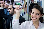 Portrait of smiling young businesswoman standing on the subway, looking away