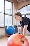 Young man using a fitness ball to exercise