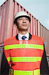 Proud engineer in protective workwear standing in a shipping yard