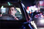 Businessman driving at night in the city