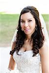 Close-up portrait of Bride in wedding gown, standing outdoors on Wedding Day, smiling and looking at camera, Canada