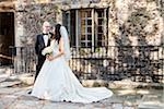 Portrait of Bride and Groom standing outdoors on Wedding Day, smiling and looking at each other, Canada