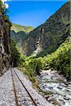 Train rails beside river on scenic journey through the Sacred Valley of the Incas in the Andes mountains, Peru