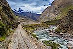 Train rails beside river on scenic journey through the Sacred Valley of the Incas in the Andes mountains, Peru