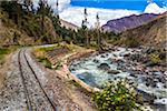 Train rails beside river on scenic journey through the Sacred Valley of the Incas in the Andes mountains, Peru