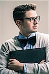 Portrait of Student wearing Bow Tie and Glasses with Binder, Studio Shot