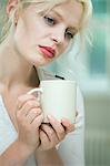 Wistful looking young woman with a coffee
