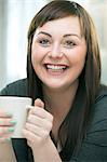 Young woman with hot drink, smiling