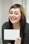 Happy young woman with a blank card