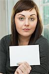 Serious young woman with a blank card