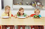 Children staring at full plate of greens