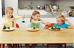 Girls scooping vegetables onto boy's plate