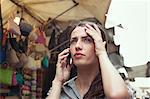 Young woman on cell phone, San Lorenzo market, Florence, Tuscany, Italy