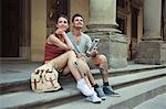 Man and woman sitting on steps of Uffizi Gallery, Florence, Tuscany, Italy