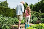 Grandfather and granddaughter holding hands in garden