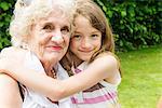 Portrait of grandmother and granddaughter hugging