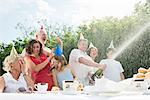 Family celebrating birthday, man opening champagne