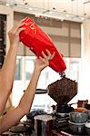 Barista pouring coffee beans into grinder