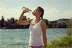 Young female jogger drinking bottled water