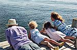 Parents and daughters lying on pier, Utvalnas, Gavle, Sweden