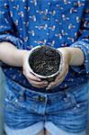 Close up of girl holding flower pot with seeds