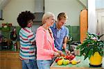 Group of friends preparing vegetables in kitchen