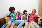 Portrait of flatmates reclining on sofa