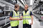 Workers checking orders in engineering warehouse