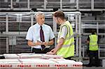 Warehouse worker and manager discussing order in engineering warehouse