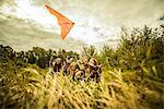 Five young women having fun with kite in scrubland