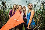 Portrait of five young women in marshes holding kite