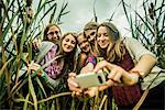 Five young women taking self portrait in marshes